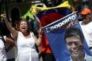 Supporters of jailed opposition leader Leopoldo Lopez, shout and hold a picture of him while they gather in support of him outside the courthouse during his trial in Caracas
