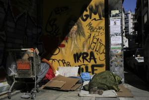 A homeless man sleeps on a pavement in Athens, on Wednesday, …