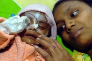 Mãe acompanha bebê em tratamento contra a pneumonia em um hospital de Dacca, Bangladesh, em janeiro de 2006