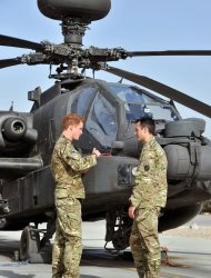 Britain's Prince Harry, left, is shown the Apache helicopter by a member of his squadron (name not provided) at Camp Bastion in Afghanistan, Friday Sept. 7, 2012. Prince Harry will be based at Camp Bastion during his tour of duty as a co-pilot gunner, returning to Afghanistan to fly attack helicopters in the fight against the Taliban. (AP Photo/John Stillwell)