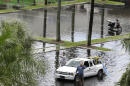 Workers pump water from the parking lot of the Dadeland Plaza shopping center, Thursday, Oct. 3, 2013, after heavy rains in Pinecrest, Fla., a suburb of Miami. Preparations began Thursday along the central Gulf Coast as newly formed Tropical Storm Karen threatened to become the first named tropical system to menace the United States this year. (AP Photo/Wilfredo Lee)