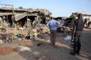 A police officer stands at the scene of a suicide bombing that killed at least at a bus station in Maiduguri, Nigeria, on June 22, 2015