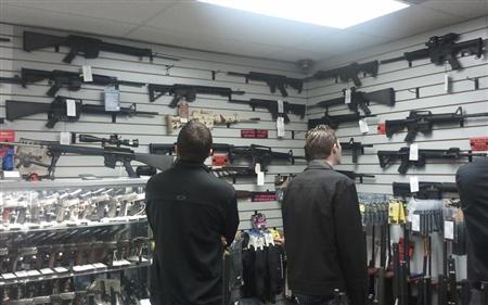 Customers view semi automatic guns on display at a gun shop in Los Angeles, California December 19, 2012. REUTERS/Gene Blevins