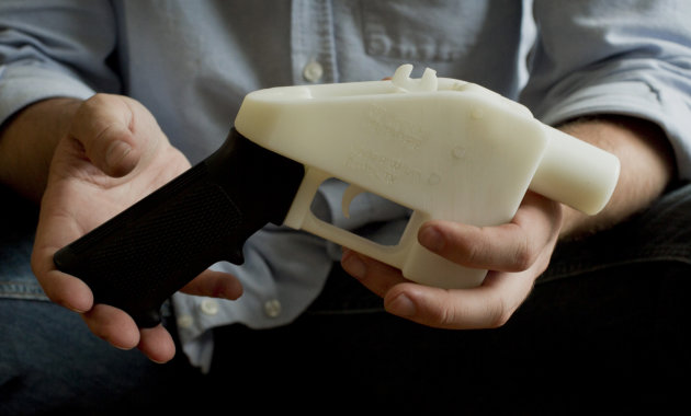 This photo taken May 10, 2013 shows Cody Wilson holding what he calls a Liberator pistol that was completely made on a 3-D-printer at his home in Austin, Texas. Congress is extending a ban on plastic firearms that can slip past airport and school metal detectors and X-ray machines, a bittersweet moment for gun control advocates just before the first anniversary of the mass killing at a Connecticut elementary school. (AP Photo/Austin American Statesman, Jay Janner) AUSTIN CHRONICLE OUT, COMMUNITY IMPACT OUT, INTERNET MUST CREDIT PHOTOGRAPHER AND STATESMAN.COM