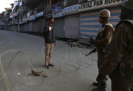 Indian paramilitary soldiers interrogate a civilian near a barbed wire set up as road blockade during curfew in Srinagar, India, Saturday, Feb. 9, 2013. A Kashmiri man Mohammed Afzal Guru, convicted in the 2001 attack on India's Parliament, has been hanged in an Indian prison, a senior Indian Home Ministry official said Saturday. On Saturday morning thousands of police and paramilitary troops had fanned out across Indian Kashmir anticipating that protests and violence might follow news of the execution. (AP Photo/Mukhtar Khan)