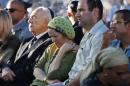 Rachel and Avi Fraenkel, parents of U.S.-Israeli national Naftali, 16, one of the three Israeli teens who were abducted and killed in the West Bank, mourn as they sit next to Israeli President Shimon Peres during their son'ss joint funeral in the Israeli city of Modiin, Tuesday, July 1, 2014. Tens of thousands of mourners converged Tuesday in central Israel for the funeral service for three teenagers found dead in the West Bank after a two week search and crackdown on the Hamas militant group, which Israeli leaders have accused of abducting and killing the young men. The deaths of Eyal Yifrah, 19, Gilad Shaar, 16, and Naftali Fraenkel, a 16-year-old with dual Israeli-American citizenship, have prompted angry calls for revenge and Prime Minister Benjamin Netanyahu convened his security Cabinet for an emergency meeting to discuss a response to the killings, hours after airstrikes targeted dozens of suspected Hamas positions in the Gaza Strip.(AP Photo/Baz Ratner, Pool)
