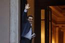 Greece's Prime Minister Alexis Tsipras waves and smiles as he arrives at Maximos Mansion in Athens, Friday, June 26, 2015. The bitter standoff between Greece and its international creditors was extended into the weekend, just days before Athens has to meet a crucial debt deadline which could decide whether it goes bankrupt and gets kicked out of the euro currency club.(AP Photo/Daniel Ochoa de Olza)
