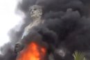 In this image taken from video obtained from Ugarit News, which has been authenticated based on its contents and other AP reporting, a statue of Hafez Assad, father of Syrian President Bashar Assad, burns after being set on fire by rebel fighters inside the grounds of the General Company of the Euphrates Dam in Al-Raqqa, Syria, Monday, Feb. 11, 2013. Syrian rebels captured the country's largest dam on Monday after days of intense clashes, giving them control over water and electricity supplies for much of the country in a major blow to President Bashar Assad's regime. (AP Photo/Ugarit News via AP video)