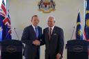 Australian Prime Minister Tony Abbott, left, shakes hand with his Malaysian counterpart Najib Razak after a joint press conference in Putrajaya, Malaysia, Saturday, Sept. 6, 2014. Abbott is on a one day visit to Malaysia. (AP Photo/Lai Seng Sin)
