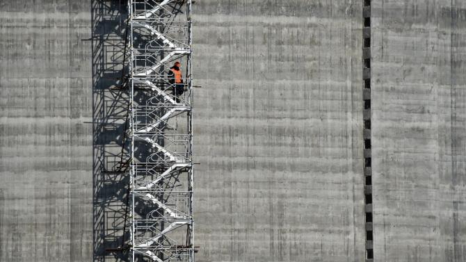 A worker standing on the stairs of a natural gas reservoir at the port of Sabetta, Russia, in the Kara Sea shore line on the Yamal Peninsula in the Arctic circle, on April 16, 2015