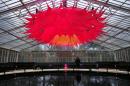 An employee poses behind a giant Lotus Flower installation in the Water Lilly House at Kew Royal Botanical Gardens in south west London on November 27, 2013