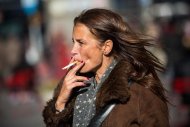 Mulher fuma cigarro na Times Square, em Nova York