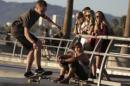 People watch a skateboarder at the Venice Skatepark in Venice, California