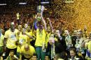 Maccabi of Tel Aviv captain Maccabi Guy Pnini holds the trophy and celebrate with teammates after winning the Euroleague Final Four final against Real Madrid in Milan, Italy, Sunday, May 18, 2014. Maccabi won 98-86. (AP Photo/Luca Bruno)