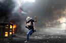 A masked Palestinian hurls rocks towards Israeli soldiers during clashes following the funeral of Mohammed Fares al-Jaabari on October 10, 2015, in the West Bank town of Hebron