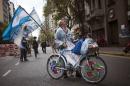 A supporter of Argentina's President Cristina Fernandez arrives in a bicycle decorated with Argentine flags at the Favaloro Hospital in Buenos Aires, Argentina, Wednesday, Oct. 9, 2013. The doctors who removed a blood clot from the brain of Argentina's president on Tuesday say she's improving without complications. (AP Photo/Victor R. Caivano)
