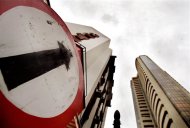 A road sign stands next to the Bombay Stock Exchange building (R), August 3, 2005. REUTERS/Arko Datta/Files
