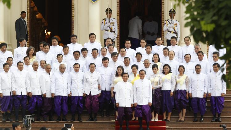 Cambodia's main opposition leader Sam Rainsy, foreground right, and his Deputy President Kem Sokha, foreground left, pose for photographs with their party lawmakers inside Royal Palace, in Phnom Penh, Cambodia, Tuesday, Aug. 5, 2014. Cambodia’s opposition lawmakers-elect took sworn in Tuesday, to get their official parliamentary immunity by ending their 10-months boycott of parliament. (AP Photo/Heng Sinith)