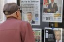 A man looks at the front pages of newspapers, with headlines about the statement of Portugal's President Silva, displayed in a shop in Sintra village