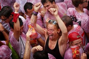 Revelers are sprayed with wine during the launch of …