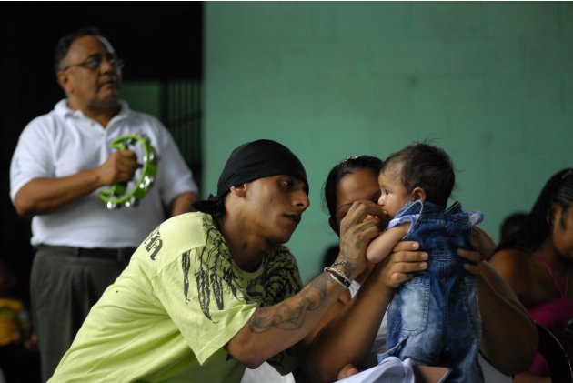 A gang member and inmate plays with his son during a religious service at a prison in Quetzaltepeque