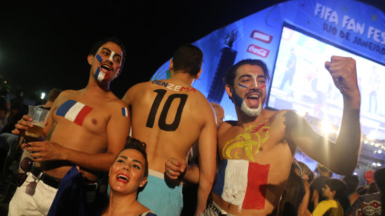 French soccer fans pose for photos after watching a live telecast of the World Cup group E match between France and Ecuador inside the FIFA Fan Fest area on Copacabana beach, in Rio de Janeiro, Brazil, Wednesday, June 25, 2014. France drew 0-0 with 10-man Ecuador to advance to the second round, while the South Americans will be going home from the tournament. (AP Photo/Leo Correa)