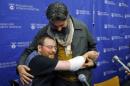Will Lautzenheiser hugs his partner Angel Gonzalez at a news conference to announce Lautzenheiser's successful double arm transplant at Brigham and Women's Hospital in Boston