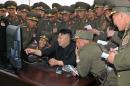 This undated picture released from North Korea's official Korean Central News Agency on April 27, 2014 shows North Korean leader Kim Jong-Un (C) looking at a computer