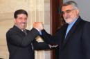 In this photo released by the Syrian official news agency SANA, Iranian parliament member Alaeddin Boroujerdi, right, shakes hands with Syrian Prime Minister Wael al-Halqi, left, in Damascus, Syria, Thursday, May 14, 2015. A prominent Iranian lawmaker has criticized the training of some Syrian rebels by the United States and its allies, calling it a "strategic mistake." The U.S. program to train Syria's moderate rebels began earlier this month in Jordan and is scheduled to expand to Turkey, Saudi Arabia and Qatar. (SANA via AP)