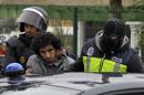 Masked Spanish National Police officers detain a man suspected to be a member of an Islamist militant cell in Melilla