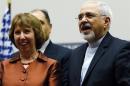 European Union foreign policy chief Ashton smiles next to Iranian Foreign Minister Zarif during a ceremony at the United Nations in Geneva