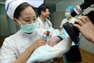 Enfermeira cuida de recém-nascido de mulher grávida de cinco meses quando foi diagnositcada com o vírus da gripe aviária em abril no leste da China