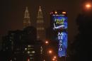 An office building is illuminated with LED lights displaying "Pray for MH370" next to Malaysia's landmark Petronas Twin Towers in Kuala Lumpur, Malaysia, Wednesday, March 19, 2014. Countless theories have surfaced about the disappearance of Malaysia Airlines Flight 370 nearly two weeks ago. (AP Photo/Lai Seng Sin)