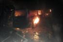 A damaged mini-van burns at the site of an explosion in the Shi'ite town of Hermel