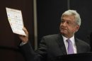 Lopez Obrador, presidential candidate for the Party of the Democratic Revolution, shows a ballot during a news conference in Mexico city