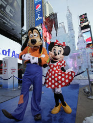 Disney characters Goofy and Minnie Mouse pose in front of a three-story castle made of ice in New York's Times Square, Wednesday, Oct. 17, 2012. On Wednesday, Disney announced a new program for 2013, "Limited Time Magic," in which guests will encounter surprise weekly themes at Disney parks in Florida and California. The program was described as "52 weeks of magical experiences big and small that appear, then disappear as the next special surprise debuts." For example, a weeklong Valentine's Day celebration might include pink lighting on Disney castles, surprise meet-and-greets with Disney characters and candlelit dinners for lovebirds. (AP Photo/Richard Drew)