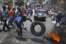 A protester burns tires on the street during a protest against President Michel Martelly's government in Port-au-Prince, Haiti, Tuesday April 15, 2014. Those demonstrating called for the resignation of Martelly.( AP Photo/Dieu Nalio Chery)
