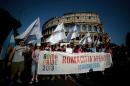 People hold a banner reading 'Rome open city' as they take part in the annual gay pride parade in downtown Rome on June 15, 2013