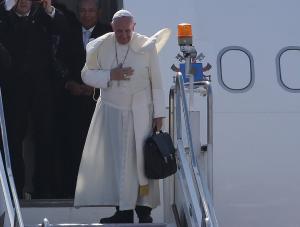 Pope Francis gestures before boarding his plane as …