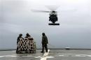 A helicopter makes an approach to the flight deck of Australian Navy ship HMAS Toowoomba to pick up supplies as they continue to search for the missing Malaysian Airlines flight MH370