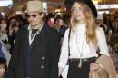 FILE - In this Jan. 26, 2015 file photo, U.S. actor Johnny Depp and Amber Heard arrive at Haneda international airport in Tokyo to promote his latest film "Mortdecai." Australian quarantine authorities have ordered Hollywood star Johnny Depp to fly his pet dogs Pistol and Boo out the country by Saturday or they will be put down. Agriculture Minister Barnaby Joyce on Thursday, May 14, 2015 accused Depp of smuggling the Yorkshire terriers aboard his private jet when he returned to Australia on April 21 to resume filming of the 5th instalment in the "Pirates of the Caribbean" movie series at Gold Coast studios. (AP Photo/Shizuo Kambayashi, File)