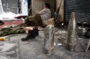 A member of the Free Syrian Army lies behind tank shells used by pro-government forces in the old part of Aleppo