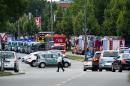 Police and firefighters near a shopping mall on July 22, 2016 in Munich, where several people were killed in a shooting rampage by a lone gunman