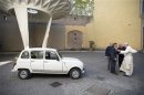 Pope Francis is presented with a Renault 4 car during a private audience with Don Zocca at the Vatican