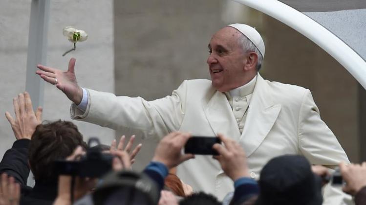 Pope Francis tries to catch a white rose thrown by a pilgrim as he arrives for his general audience at St Peter&#39;s square on March 26, 2014 at the Vatican