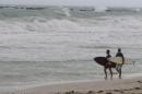 Surfers look at the Atlantic Ocean as Tropical Storm Bonnie made landfall in Miami Beach