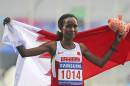 Bahrain's Eunice Jepkirui Kirwa holds her nations flag high after she finished the women's marathon at the 17th Asian Games in Incheon, South Korea, Thursday, Oct. 2, 2014.(AP Photo/Rob Griffith)
