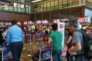 Passengers queue at the AirAsia check-in counter before their departure at Singapore Changi airport terminal on December 28, 2014
