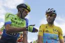 Spain's Alberto Contador gestures when talking to Italy's Vincenzo Nibali, wearing the overall leader's yellow jersey, prior to the start of the third stage of the Tour de France cycling race over 155 kilometers (96.3 miles) with start in Cambridge and finish in London, England, Monday, July 7, 2014. (AP Photo/Christophe Ena)