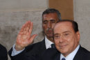 Italian former Premier Silvio Berlusconi waves to reporters as he leaves after attending a meeting with the People of Freedom party's lawmakers at the Lower Chamber in Rome, Friday, Aug. 2, 2013. Italy's former premier, Silvio Berlusconi, for the first time in decades of criminal prosecutions related to his media empire was definitively convicted of tax fraud and sentenced to prison by the nation's highest court, Judge Antonio Esposito, in reading the court's decision Thursday, declared Berlusconi's conviction and four-year prison term "irrevocable." He also ordered another court to review the length of a ban on public office — the most incendiary element of the conviction because it threatens to interrupt, if not end, Berlusconi's political career. (AP Photo/Riccardo De Luca)
